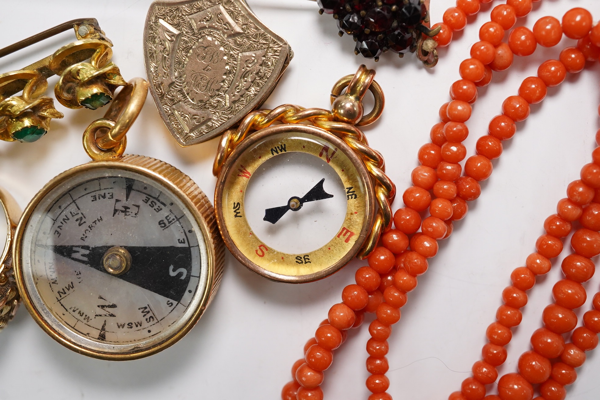 A small group of assorted jewellery including a coral necklace, 9c compass fob, five yellow metal items including a ring, locket and brooch and a stick pin. Condition - poor to fair